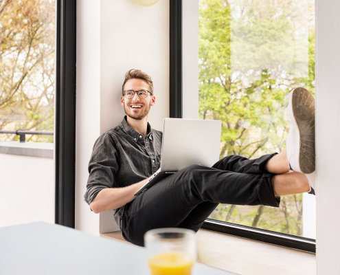 Portrait-Aufnahme von einem jungen Mann in einer stylischen Wohnung.